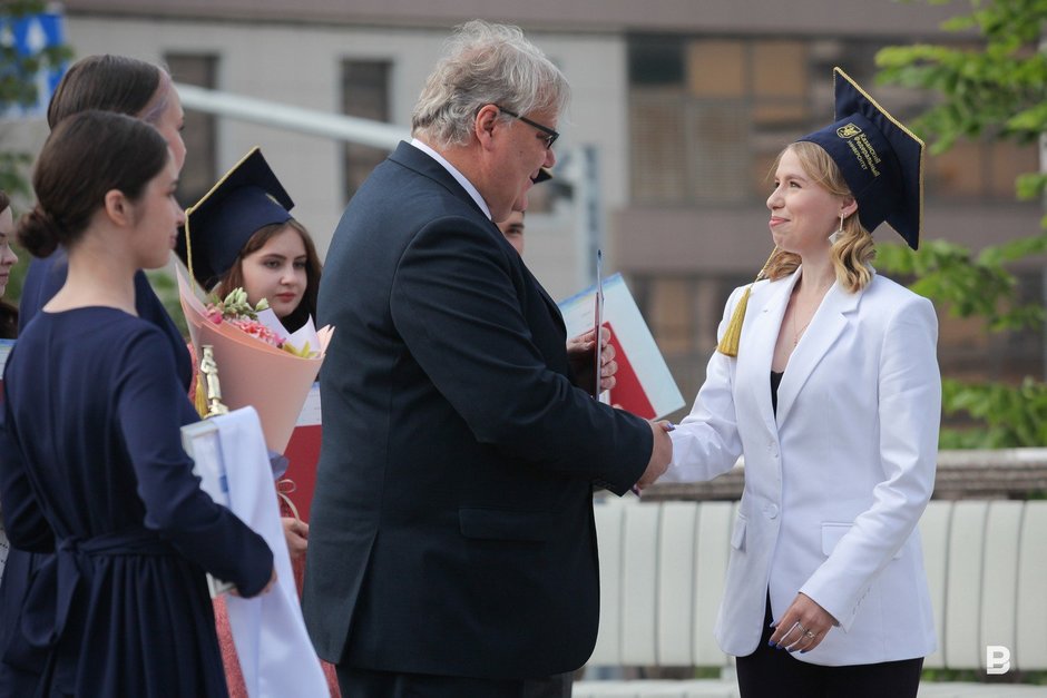 и. о. ректора КФУ Дмитрий Таюрский вручает красный диплом выпускницам