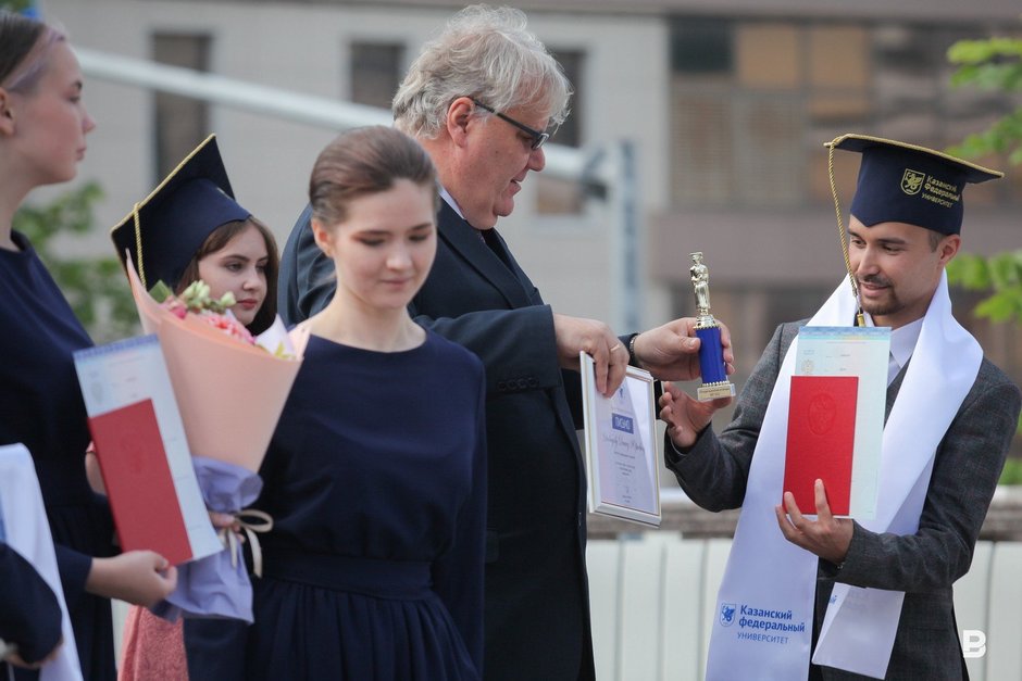 и. о. ректора КФУ Дмитрий Таюрский вручает красный диплом выпускникам